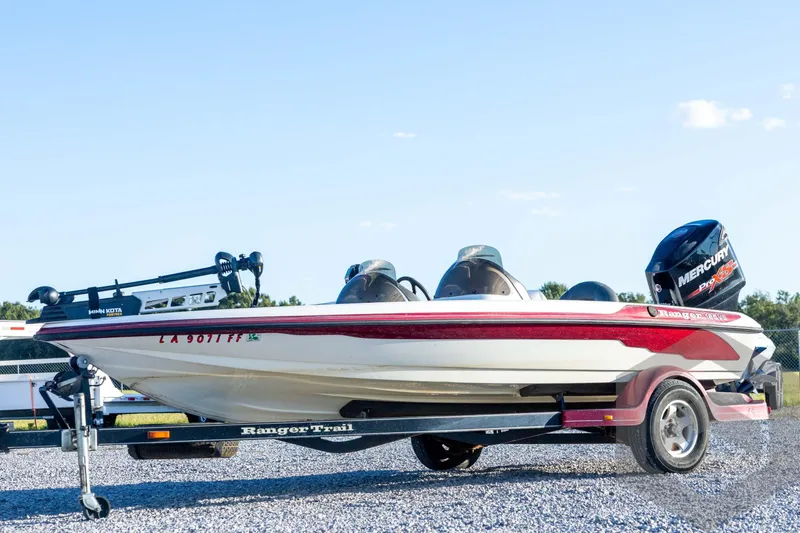 The Image of 2002 Ranger 185 VS boat on trailer with Mercury engine, parked on gravel. - 1
