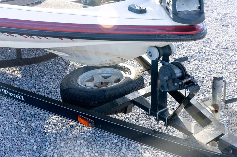 Slide: The Image of 2002 Ranger 185 VS boat on trailer with spare tire, parked on gravel. - 11