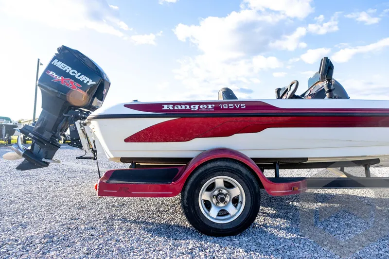 Slide: The Image of 2002 Ranger 185 VS boat with Mercury engine on a trailer, parked on gravel. - 12