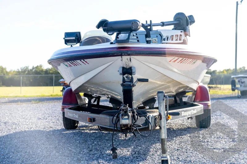 Slide: The Image of 2002 Ranger 185 VS boat on trailer, equipped with Minn Kota motor, parked on gravel. - 2