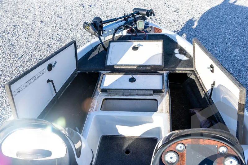 Slide: The Image of 2002 Ranger 185 VS boat interior with open storage compartments and control panel. - 34