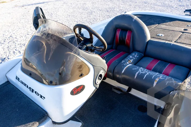 Slide: The Image of 2002 Ranger 185 VS boat interior with worn seats and steering console. - 41
