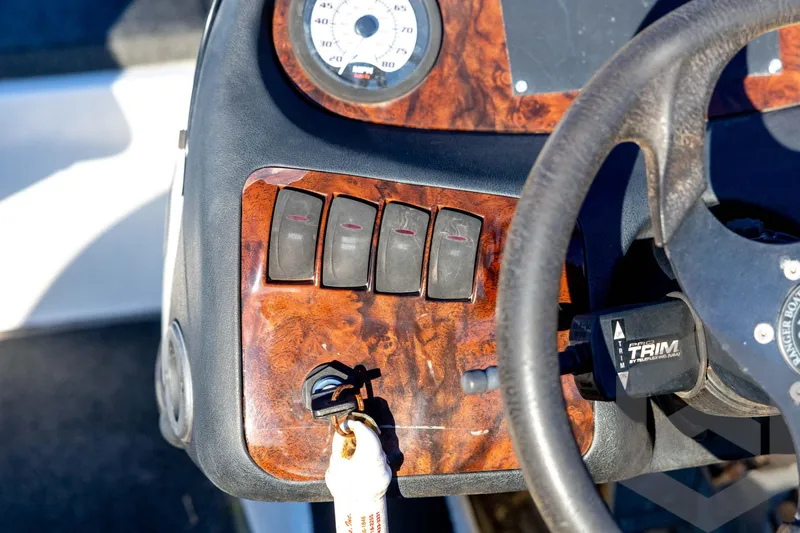 Slide: The Image of 2002 Ranger 185 VS boat dashboard with wood paneling and steering wheel. - 44