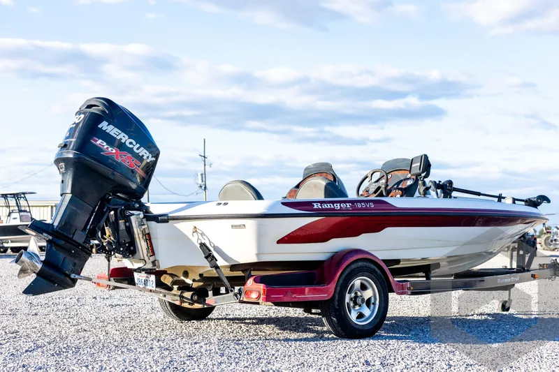 Slide: The Image of 2002 Ranger 185 VS boat with Mercury engine on a trailer, parked on gravel. - 5