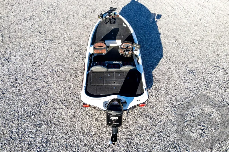 Slide: The Image of 2002 Ranger 185 VS boat, aerial view on gravel surface, showcasing interior layout and motor. - 61