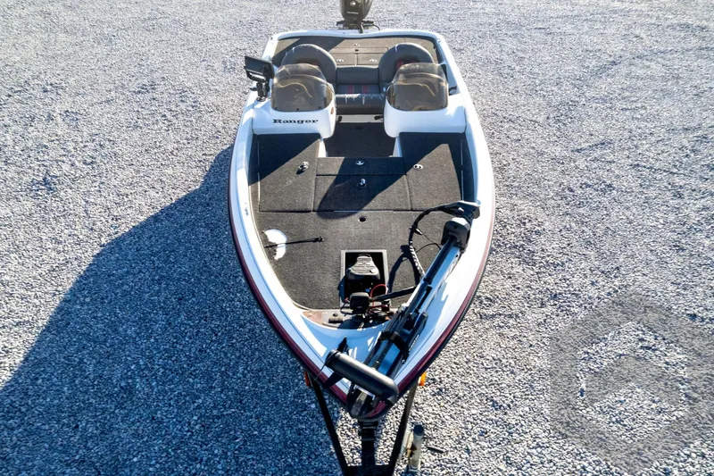 Slide: The Image of 2002 Ranger 185 VS boat on gravel, featuring dual seats and fishing equipment. - 70