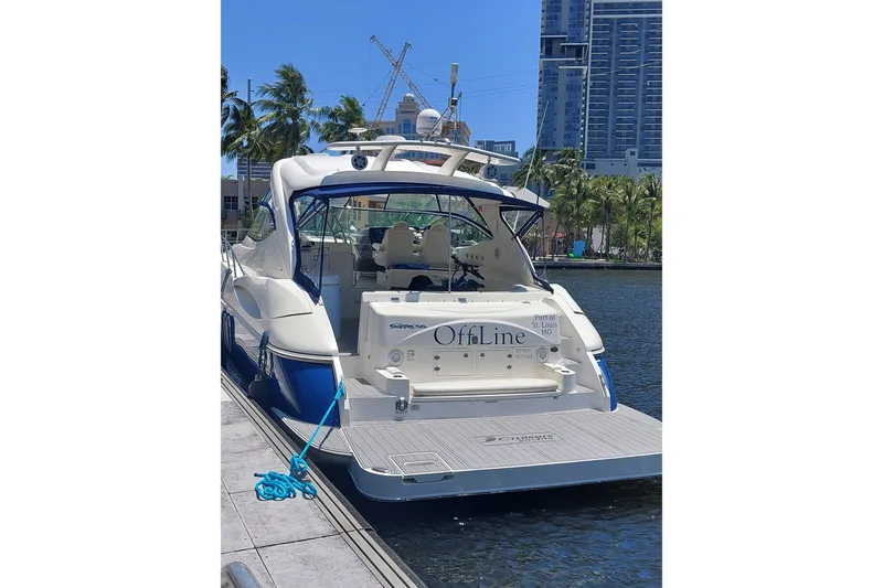 Slide: The Image of 2006 Cruisers Yachts 520 Express docked, with cityscape and palm trees in the background. - 6