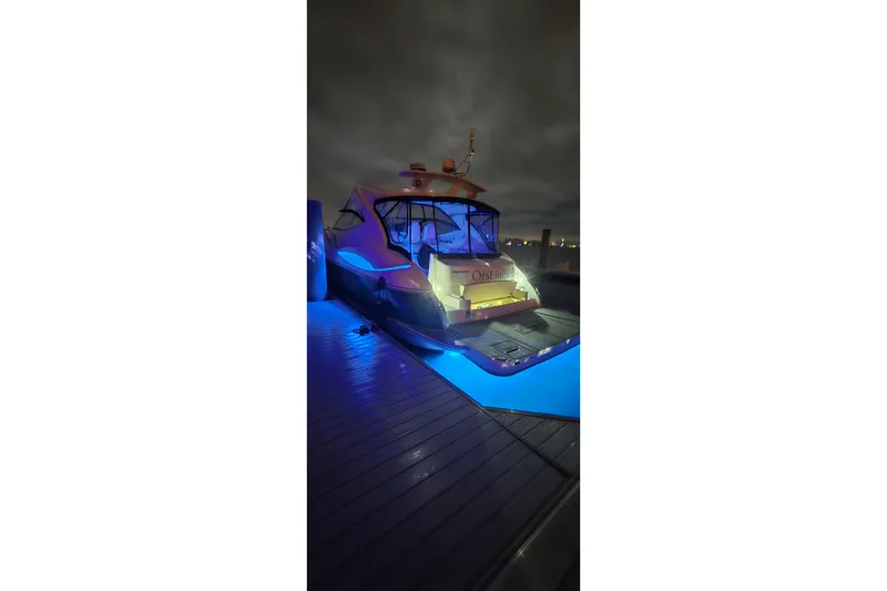 Slide: The Image of 2006 Cruisers Yachts 520 Express docked at night with blue lighting. - 15