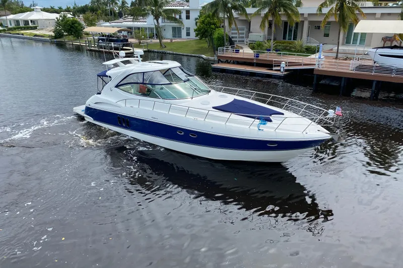 Slide: The Image of 2006 Cruisers Yachts 520 Express on a serene waterway near luxury homes. - 2