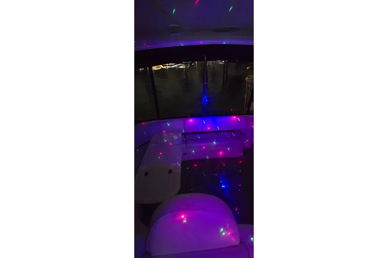 Slide: The Image of 2006 Cruisers Yachts 520 Express interior with colorful LED lights at night. - 20