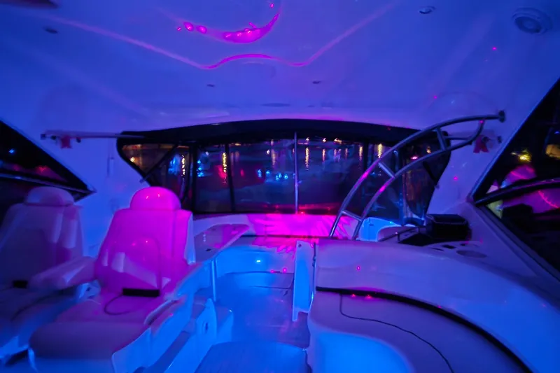 Slide: The Image of Interior of 2006 Cruisers Yachts 520 Express with vibrant pink and blue lighting. - 22