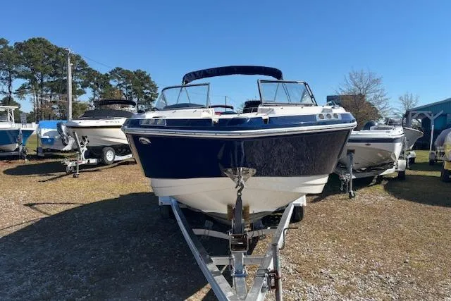 Slide: The Image of 2018 Chaparral 230 Suncoast boat on trailer, parked outdoors under clear blue sky. - 2