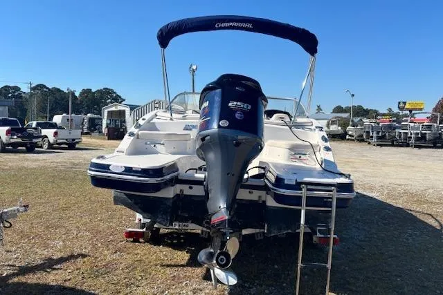 Slide: The Image of 2018 Chaparral 230 Suncoast boat with outboard motor and canopy, parked on grass. - 7