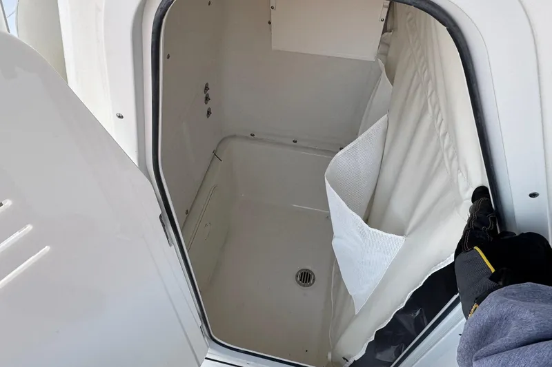 Slide: The Image of 2026 Key West 244 Center Console boat interior storage compartment with white finish and drain. - 15