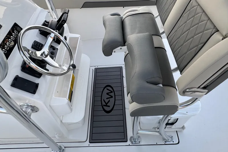 Slide: The Image of 2026 Key West 244 Center Console boat interior with steering wheel and cushioned seating. - 16