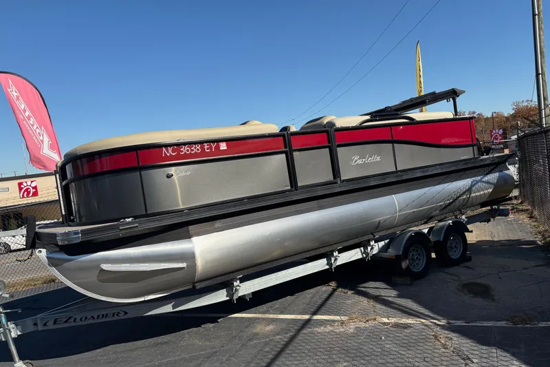 The Image of 2022 Barletta Cabrio 22Q pontoon boat on trailer, displayed outdoors under clear blue sky. - 0