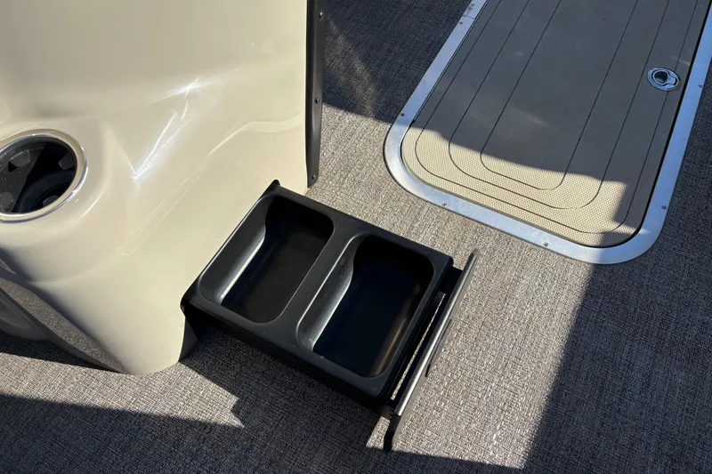 Slide: The Image of 2022 Barletta Cabrio 22Q boat interior with retractable storage drawer and cup holder. - 11
