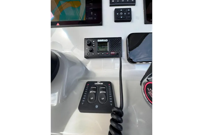 Slide: The Image of 2024 Boston Whaler 280 Outrage dashboard with Simrad and Lenco controls. - 19