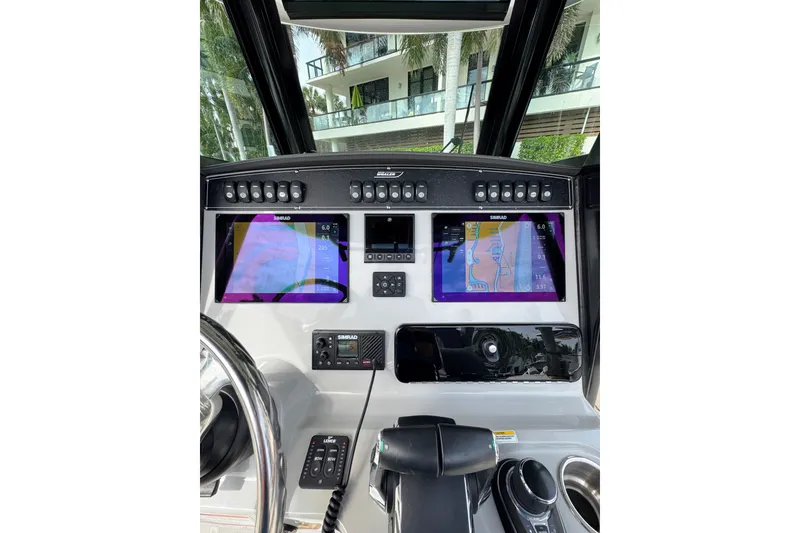 Slide: The Image of 2024 Boston Whaler 280 Outrage dashboard with advanced navigation displays and controls. - 23