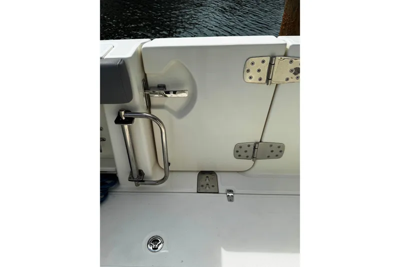 Slide: The Image of 2024 Boston Whaler 280 Outrage boat door with stainless steel hardware and water view. - 26