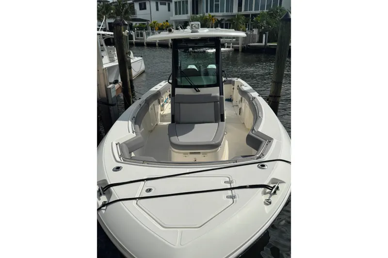 Slide: The Image of 2024 Boston Whaler 280 Outrage boat docked, showcasing spacious seating and sleek design. - 4