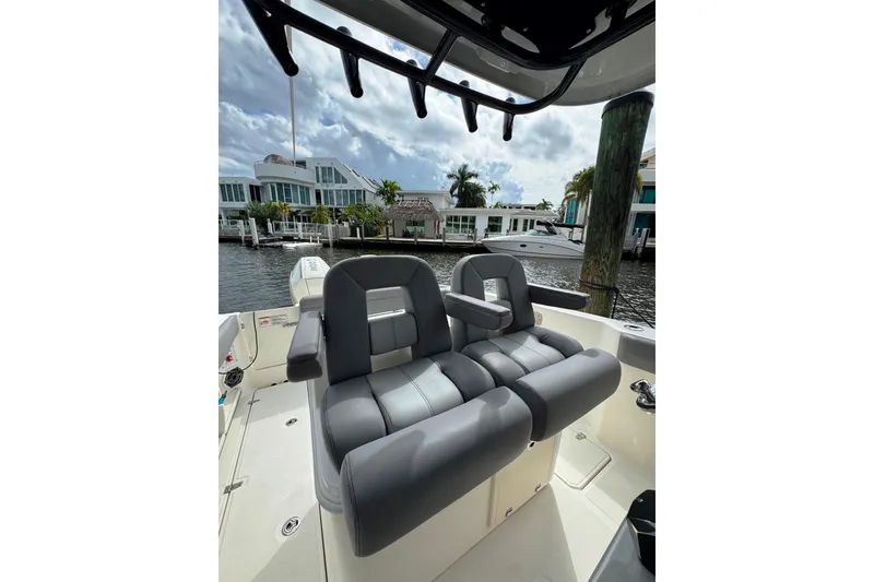 Slide: The Image of 2024 Boston Whaler 280 Outrage boat interior with luxurious seating and waterfront view. - 9