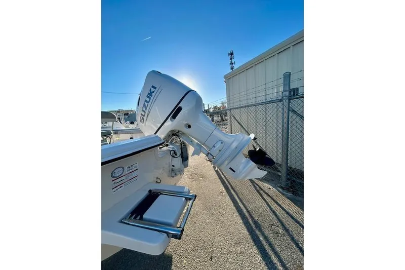 Slide: The Image of 2025 Carolina Skiff 19 LS with Suzuki outboard motor in a sunny marina setting. - 6