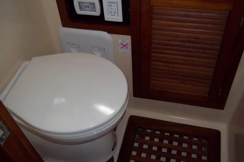 Slide: The Image of 1984 Slocum 43 yacht bathroom with toilet and wooden cabinet. - 10