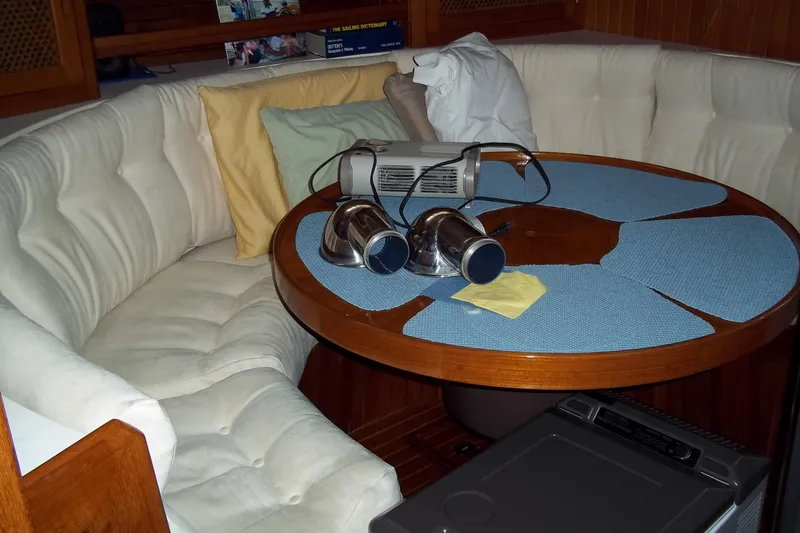 Slide: The Image of Cozy interior of 1984 Slocum 43 yacht with round table and cushioned seating. - 11