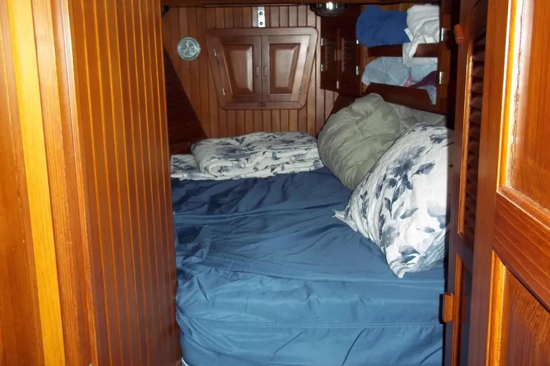 Slide: The Image of Cozy cabin interior of 1984 Slocum 43 sailboat with wooden paneling and bedding. - 12