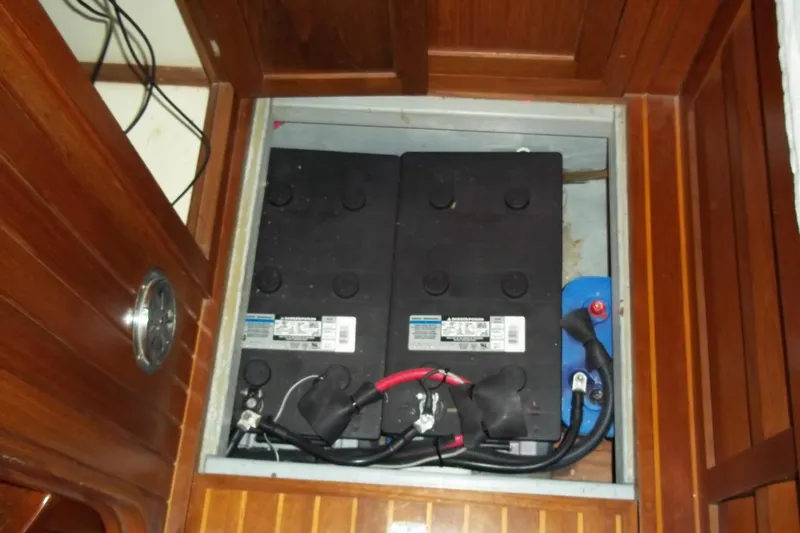 Slide: The Image of Battery compartment in a 1984 Slocum 43 sailboat, featuring dual batteries and wiring. - 14