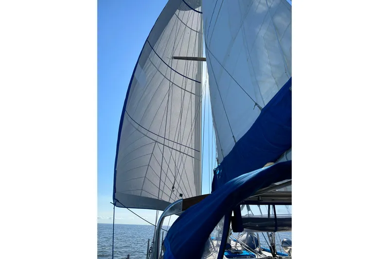 Slide: The Image of Sailing on a 1984 Slocum 43 yacht with full sails against a clear blue sky. - 4
