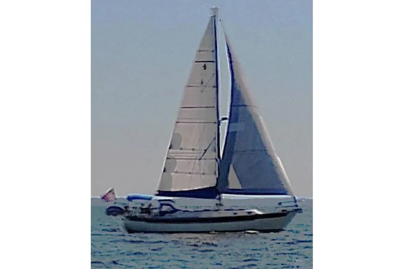 Slide: The Image of 1984 Slocum 43 sailboat cruising on open water with full sails. - 7