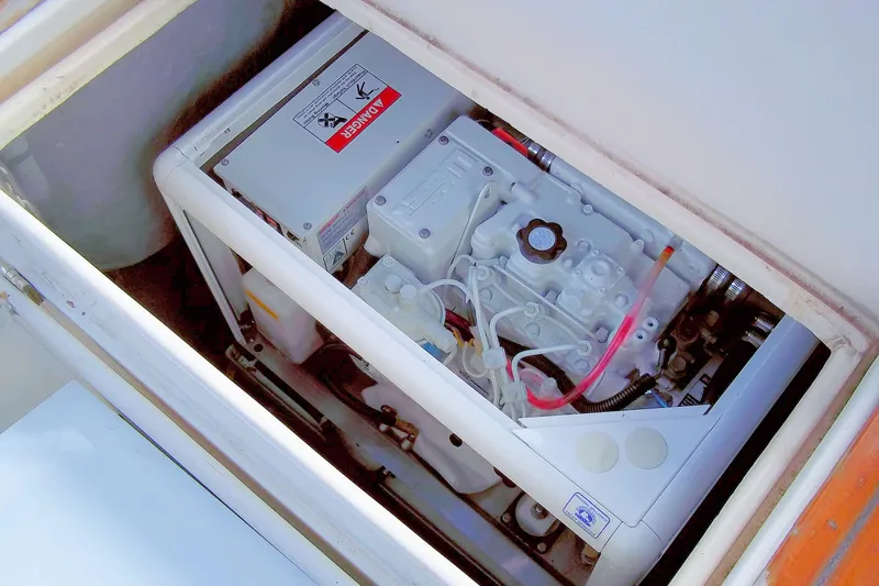 Slide: The Image of Engine compartment of a 1984 Slocum 43 sailboat, featuring mechanical components and warning labels. - 9