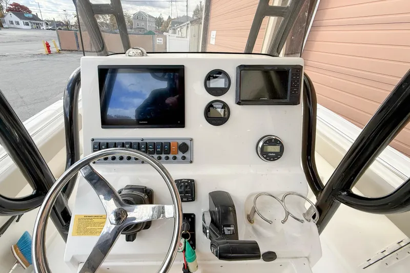 Slide: The Image of 2022 Key West 239 FS boat dashboard with steering wheel and navigation instruments. - 7