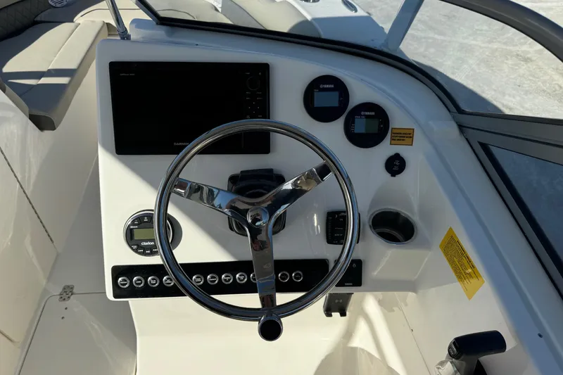 Slide: The Image of 2025 Key West 239 DFS boat dashboard with steering wheel and electronic controls. - 16