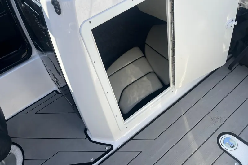 Slide: The Image of 2019 Yamaha Boats 212X storage compartment with cushioned interior and sleek deck design. - 6