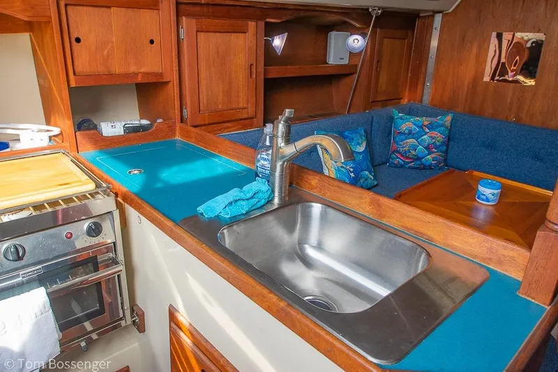 Slide: The Image of 1984 Catalina 36 yacht interior with kitchen sink, stove, and cozy seating area. - 10
