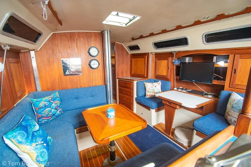 Slide: The Image of Interior of a 1984 Catalina 36 sailboat with cozy seating and wooden accents. - 13