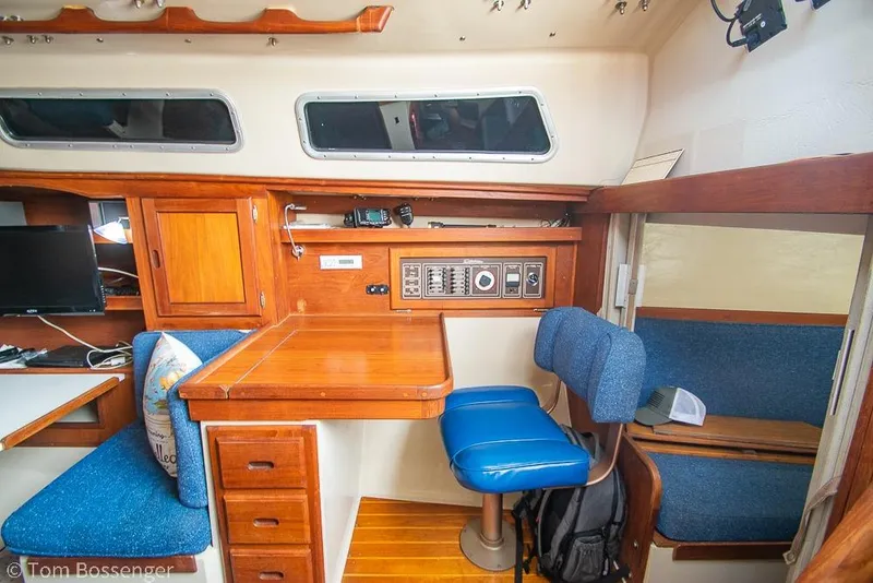 Slide: The Image of Interior of a 1984 Catalina 36 sailboat with wooden cabinetry and blue seating. - 14