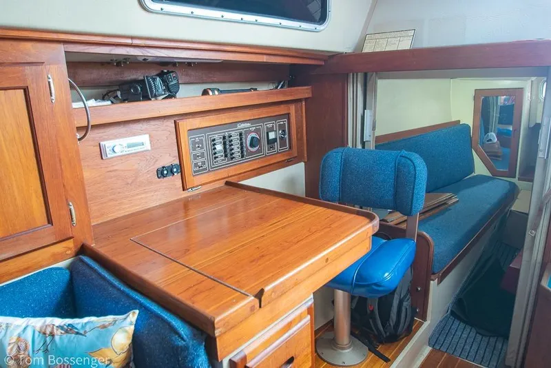 Slide: The Image of Interior of a 1984 Catalina 36 sailboat with wooden cabinetry and blue seating. - 22