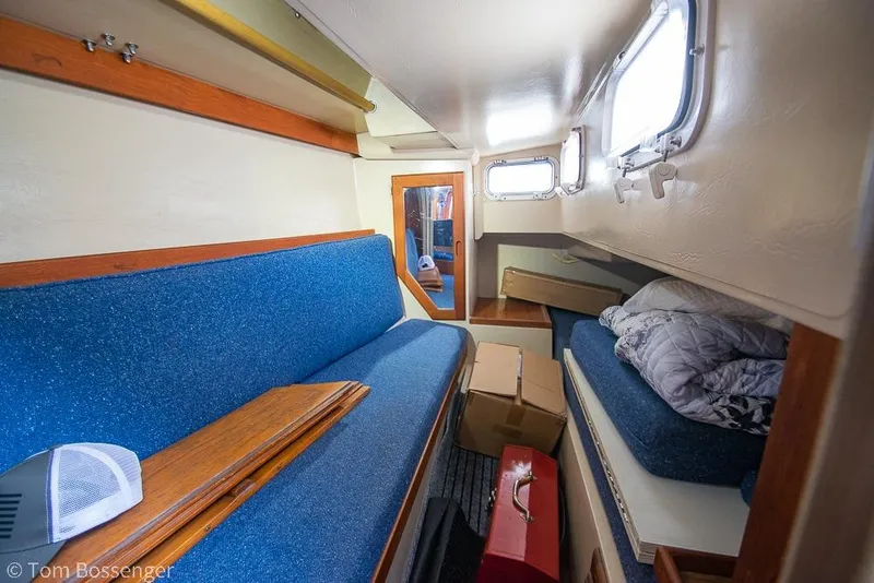 Slide: The Image of Interior of 1984 Catalina 36 sailboat with blue seating and storage boxes. - 23