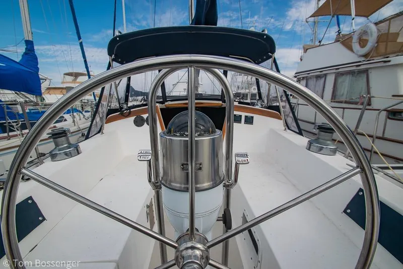 Slide: The Image of 1984 Catalina 36 sailboat cockpit with steering wheel and compass, docked in marina. - 27