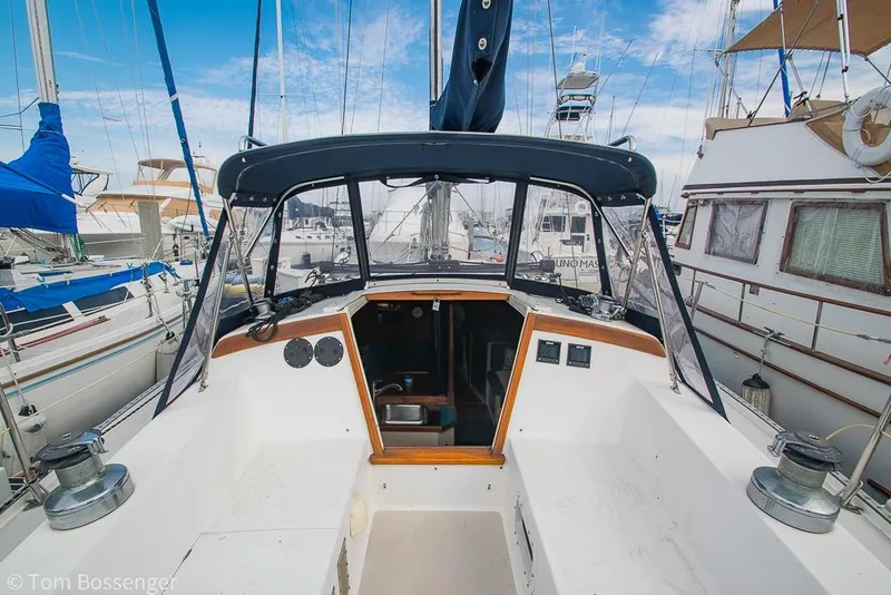 Slide: The Image of 1984 Catalina 36 sailboat cockpit with canopy, docked among other boats. - 28