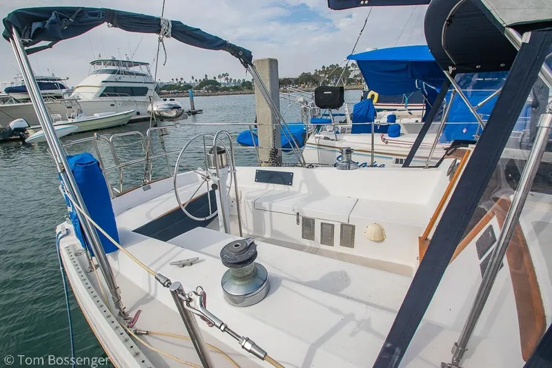 Slide: The Image of 1984 Catalina 36 sailboat docked in marina, featuring spacious cockpit and blue covers. - 4
