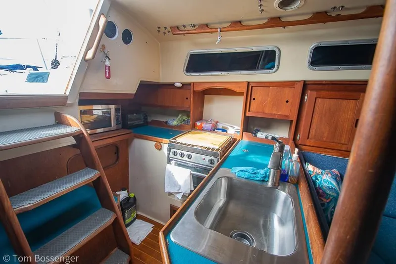 Slide: The Image of Interior of 1984 Catalina 36 sailboat galley with sink, stove, and wooden cabinetry. - 8