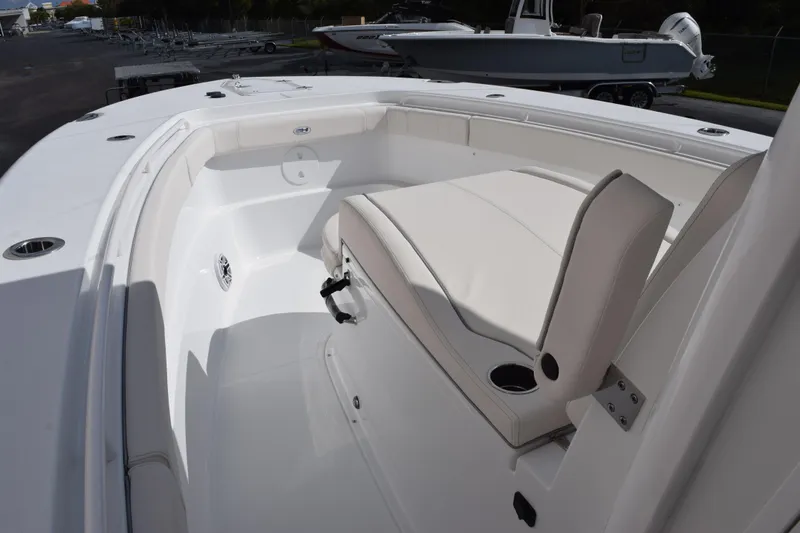 Slide: The Image of 2026 Sea Hunt Ultra 305 Coffin Box boat interior with white seating and cup holders. - 13