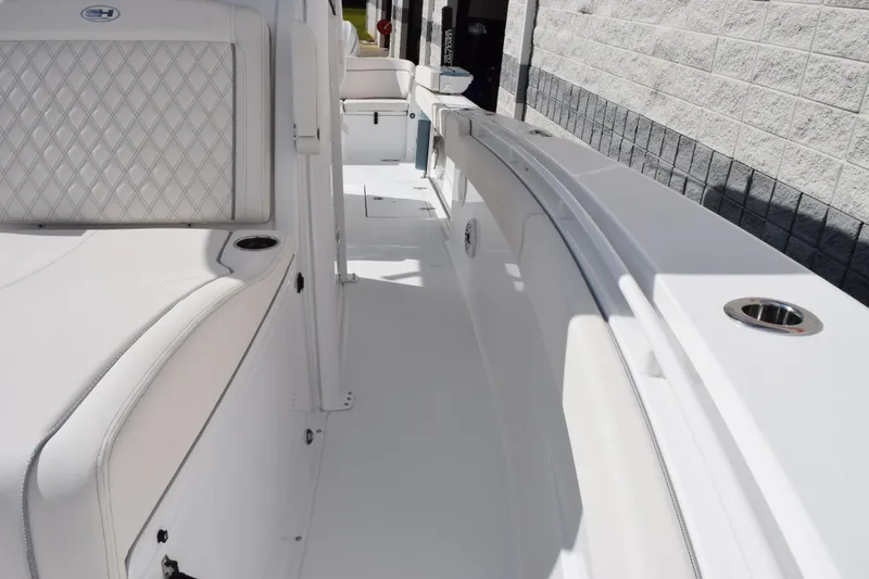 Slide: The Image of 2026 Sea Hunt Ultra 305 Coffin Box boat interior with white seating and cup holders. - 15