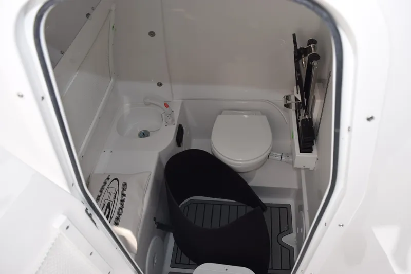 Slide: The Image of Interior of 2026 Sea Hunt Ultra 305 Coffin Box boat, featuring compact bathroom amenities. - 17