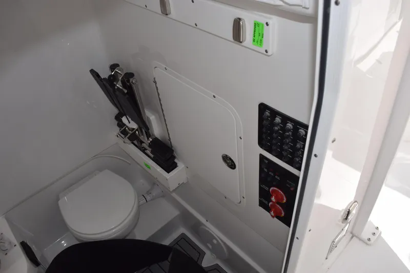 Slide: The Image of Interior of 2026 Sea Hunt Ultra 305 Coffin Box boat, featuring a compact bathroom setup. - 18